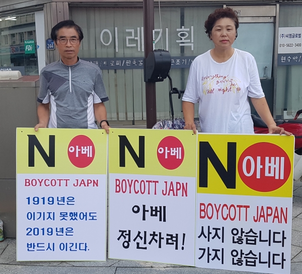 일본 아베 정부가 한국에 대한 수출 규제 조치로 인해 일본 제품 불매 운동이 들뿔처럼 번지고 있는 가운데 청양군의 주민도 폭염을 무릎쓰고 불매운동피켓을 들고 불매운동을 벌이고 있다. ( 사진은 16일 청양읍 읍내사가리에서 일본 제품 불매운동을 하는 화성면 신기환씨와 윤예주씨)