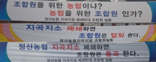 정산농협지곡지점 폐쇄결정을 반대하는 조합원들이 현수막을 내걸고 반매입장을 표명하고 있다