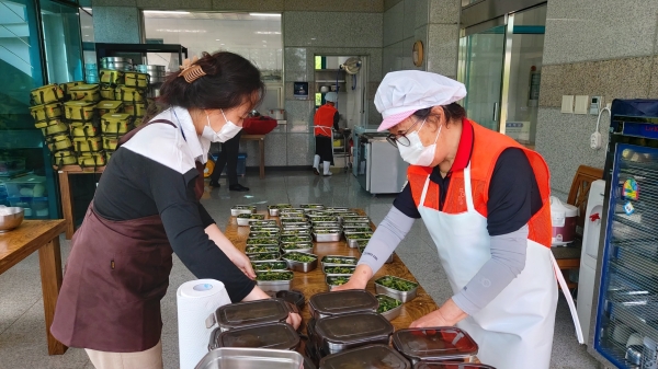 지역사회통합돌봄 대상자에게 전달될 밑반찬을 담고있는 봉사자들